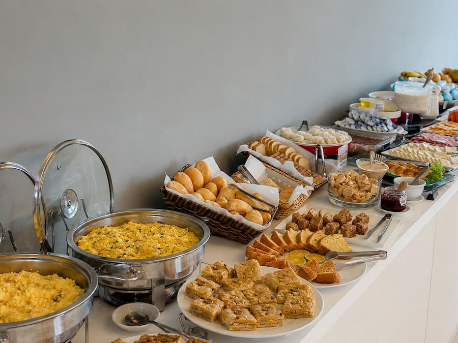 A buffet with various food items and utensils.