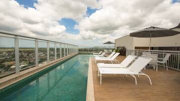 Een buitenzwembad, parasols voor strand/zwembad