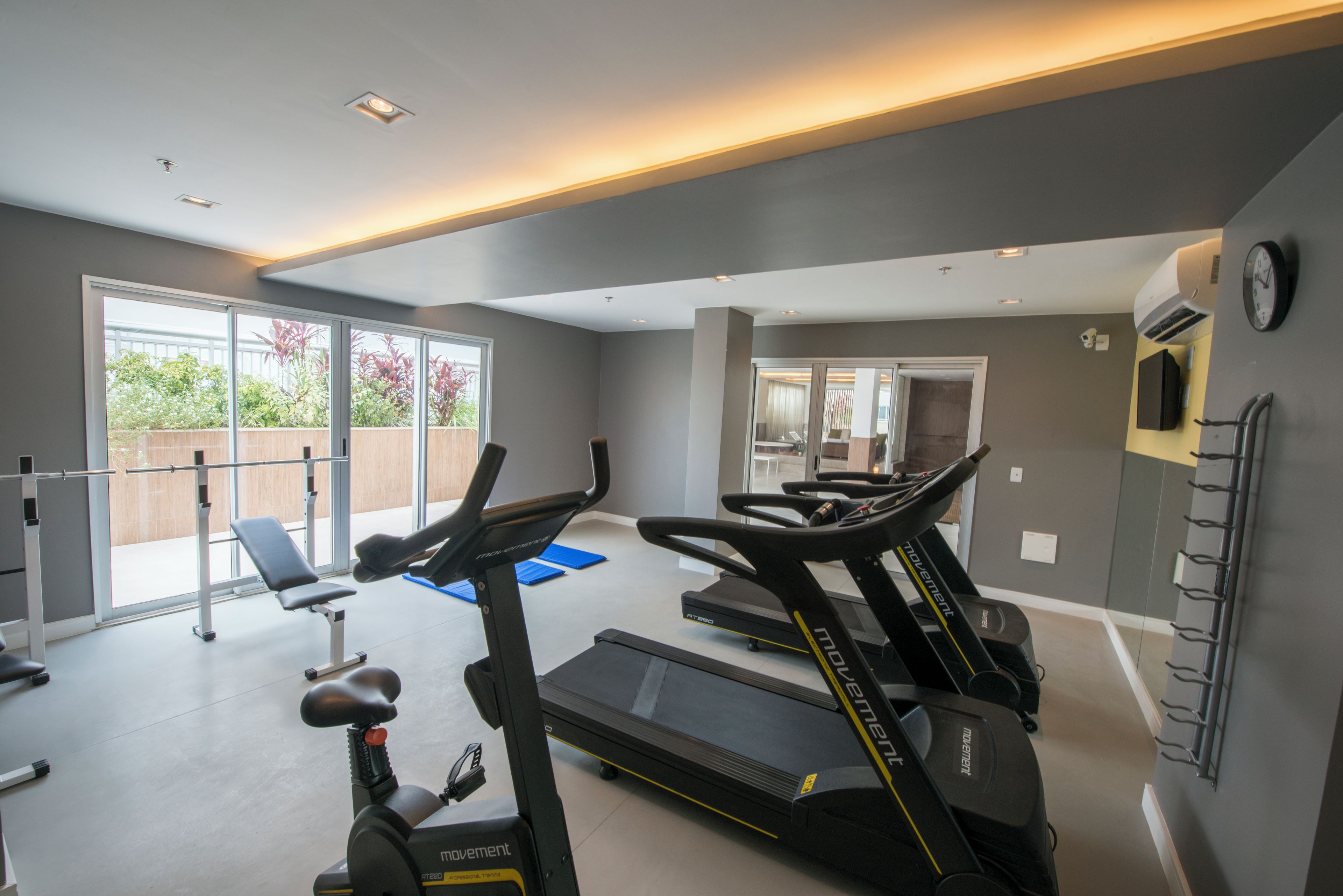 A gym with treadmills, a bench, and a weight machine.