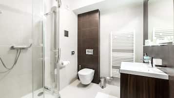 Une salle de bain moderne avec une douche à parois de verre, des toilettes blanches et un meuble-lavabo en bois avec un évier.