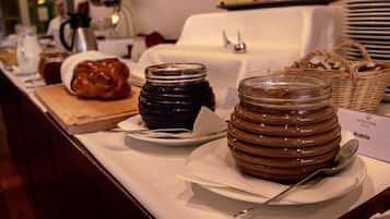 Presentación de alimentos que incluye frascos de mermelada y una hogaza de pan, con un letrero que dice 'Nutella'.