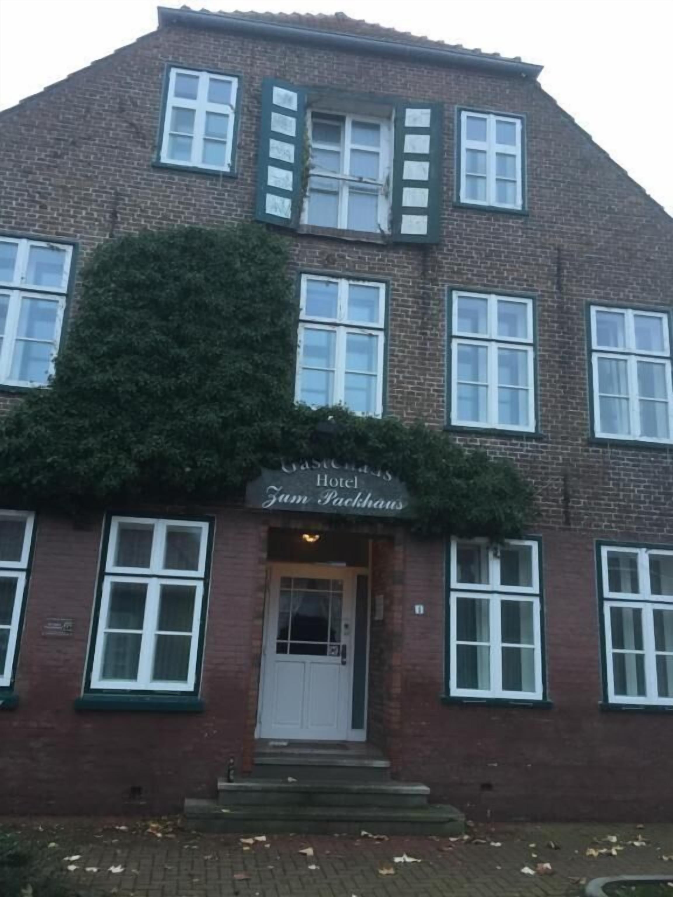 Een gebouw van baksteen met een bord waarop 'Hotel Van Packhuizen' staat.