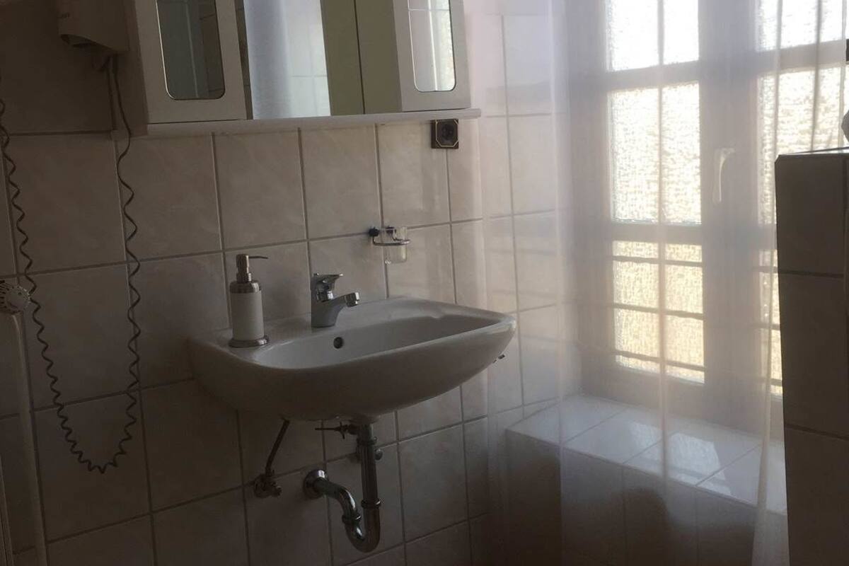 A bathroom with a sink, mirror, and toilet.