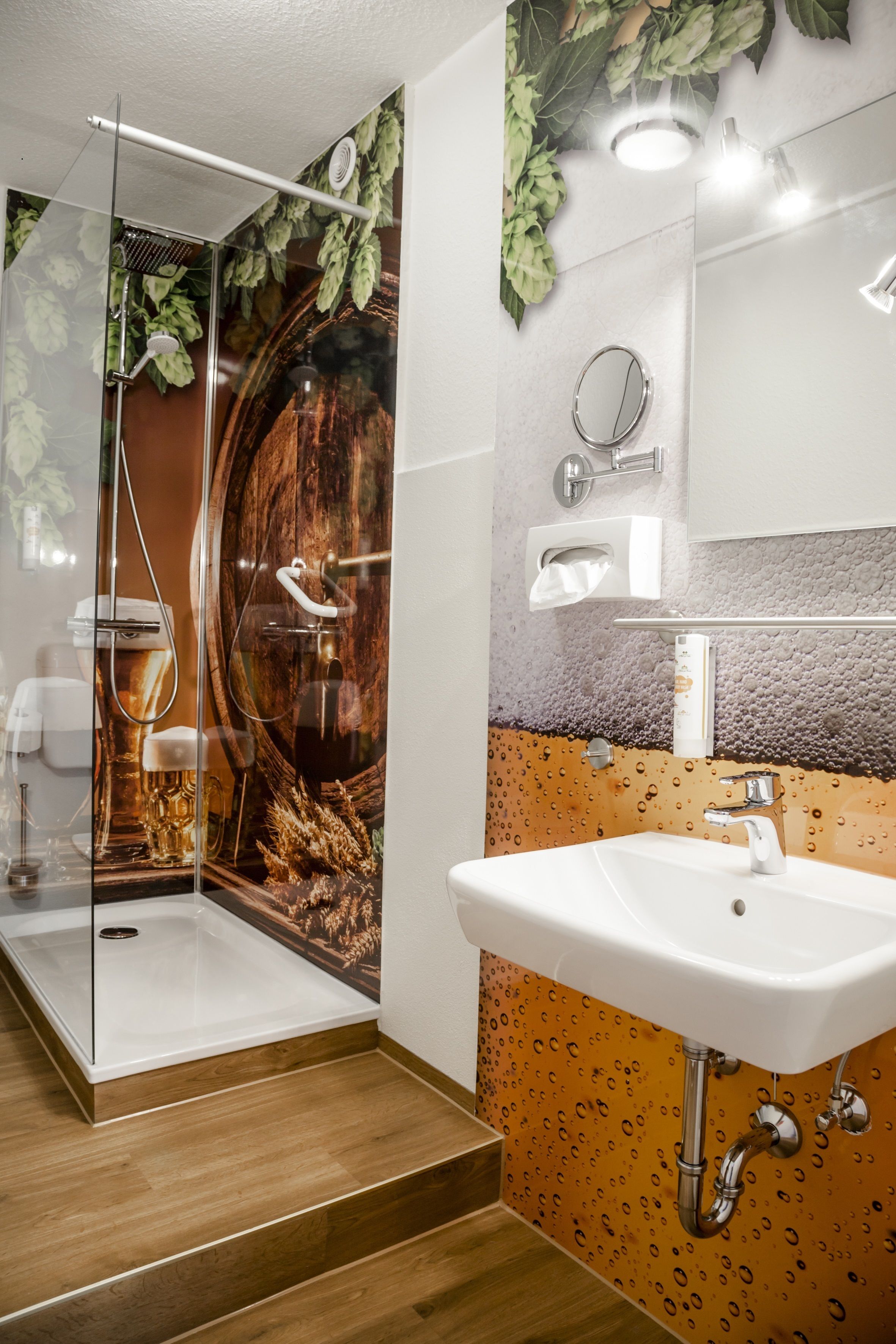Un baño con ducha acristalada, lavamanos y espejo.