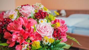 Ein Blumenstrauß mit verschiedenen Farben und Sorten, darunter Rosen und Lilien, auf einer Oberfläche platziert.