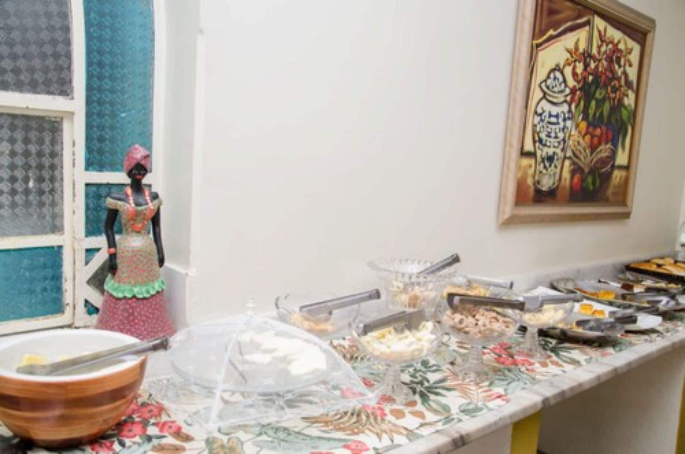 Montaje de bufé con diferentes alimentos y una muñeca decorativa sobre una mesa.