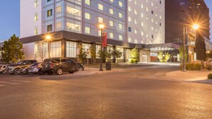 Een Courtyard Marriott hotel met een modern design, meerdere verdiepingen en een goed verlichte entree.