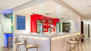 Een moderne receptiebalie met een bar, zitplaatsen en een Travelodge bord.
