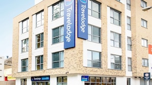 Un hôtel Travelodge doté d’une façade moderne en briques, de nombreuses fenêtres et d’une signalétique claire.
