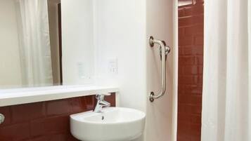 A bathroom with a white sink, a toilet, and a shower with a curtain.