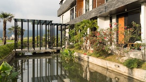 A modern building with a rooftop garden, a small pond, and a pergola structure. - Sunrise Bed and Breakfast (Dongshan)