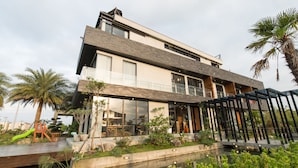 A modern two-story house with a balcony, a swimming pool, and a children's play area. - Sunrise Bed and Breakfast (Dongshan)