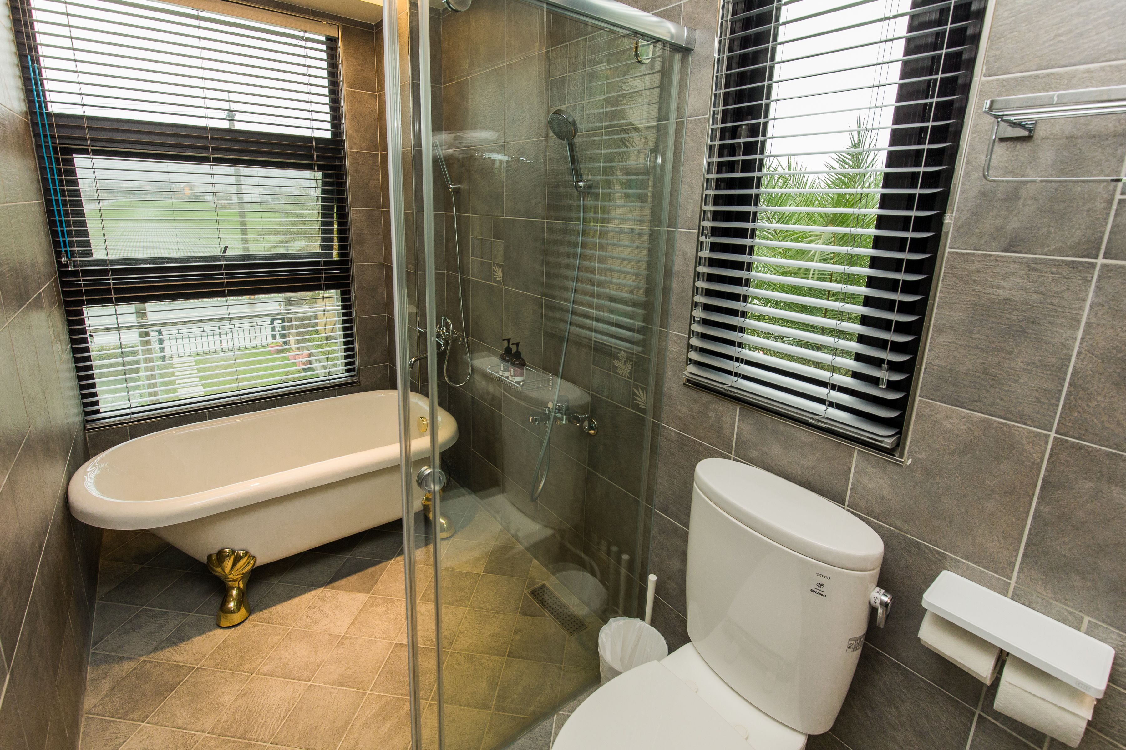 Un baño con ducha de vidrio, inodoro blanco y bañera.