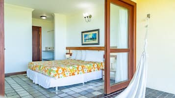 Una habitación de hotel con una cama, un cuadro en la pared, una hamaca y suelo de baldosas.