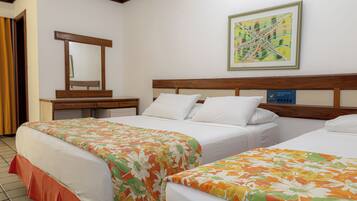 A hotel room with two beds, a wooden headboard, a desk, a mirror, and a framed abstract painting.