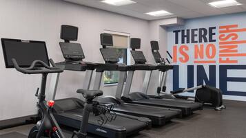 A gym with treadmills, elliptical machines, and stationary bikes.