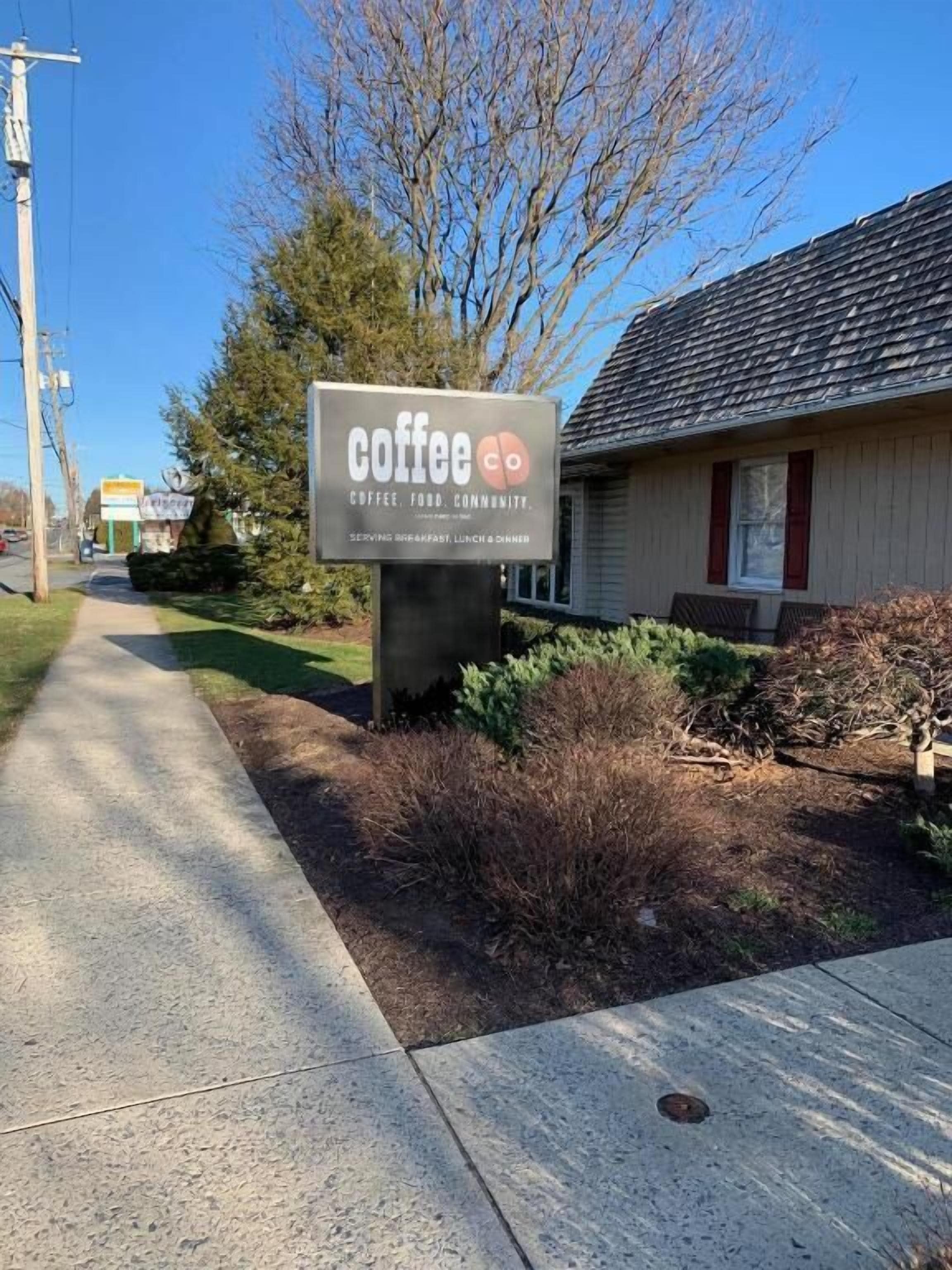 Segnaletica per un caffè chiamato 'Coffee Co', con un percorso ben definito che vi conduce.