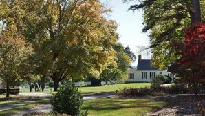 Une maison avec une pelouse bien entretenue et des arbres au premier plan.