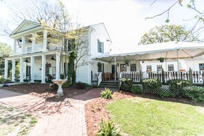 A two-story house with a covered porch and a front yard.