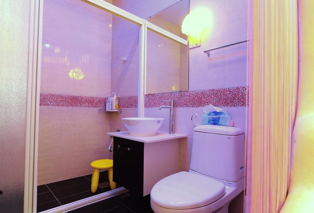 A small bathroom with a toilet, sink, and a mirror.