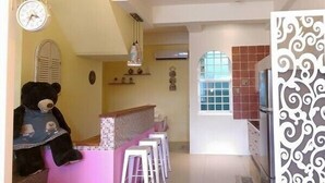 Une cuisine avec un coin bar, une horloge et un panneau décoratif mural.