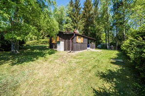 A rustic cabin with a chimney, surrounded by dense forest. - Chata Kytlice (Kytlice)