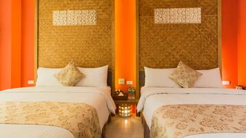 A hotel room with two beds, a nightstand, and a wall-mounted light fixture.