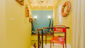 Uma escadaria com uma cadeira vermelha com a palavra 'PEACE' e um salva-vidas na parede.