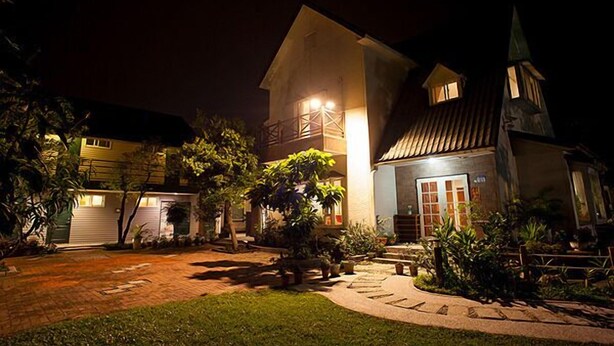A two-story building with a large garage, a covered patio, and a small tower-like structure. - Yi Shin Garden Hostel (Shoufeng)