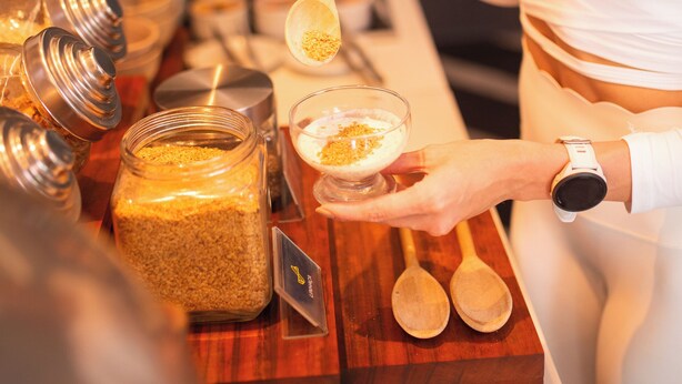 A person preparing a drink with various ingredients and utensils on a wooden counter. - Hotel Serrano (Campina Grande)