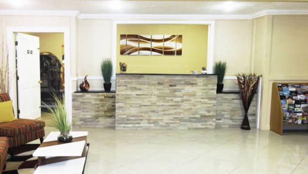 Un amplio vestíbulo con mostrador de recepción, un sofá y una mesa de centro.
