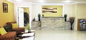 A spacious lobby with a reception desk, a sofa, and a coffee table.