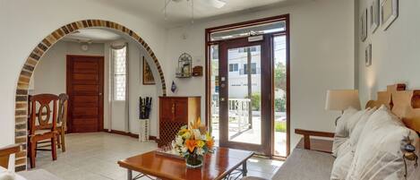 A spacious living room with a wooden table, a sofa, and a ceiling fan.