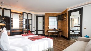 A hotel room with a large bed, a desk, a chair, a TV, and a mirror. - Only YOU Hotel Atocha (Madrid)