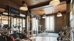 A gym with exercise equipment, a sign reading "Only YOU Hotels", and large windows allowing natural light. - Only YOU Hotel Atocha (Madrid)