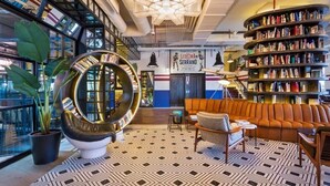 Una biblioteca moderna con una estantería circular, un sofá de cuero y un suelo con diseño.