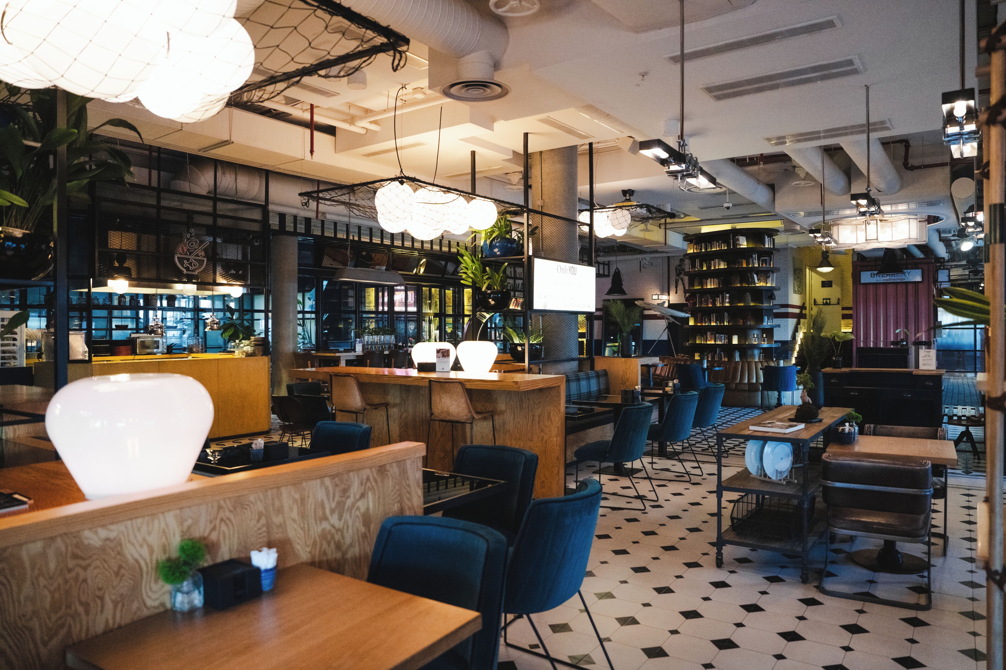 Un interior moderno con una zona de bar, asientos y un suelo estampado.
