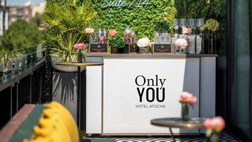 A bar area with a sign reading 'Only YOU HOTEL ATOCHA' and 'Suite 714' above a green wall.