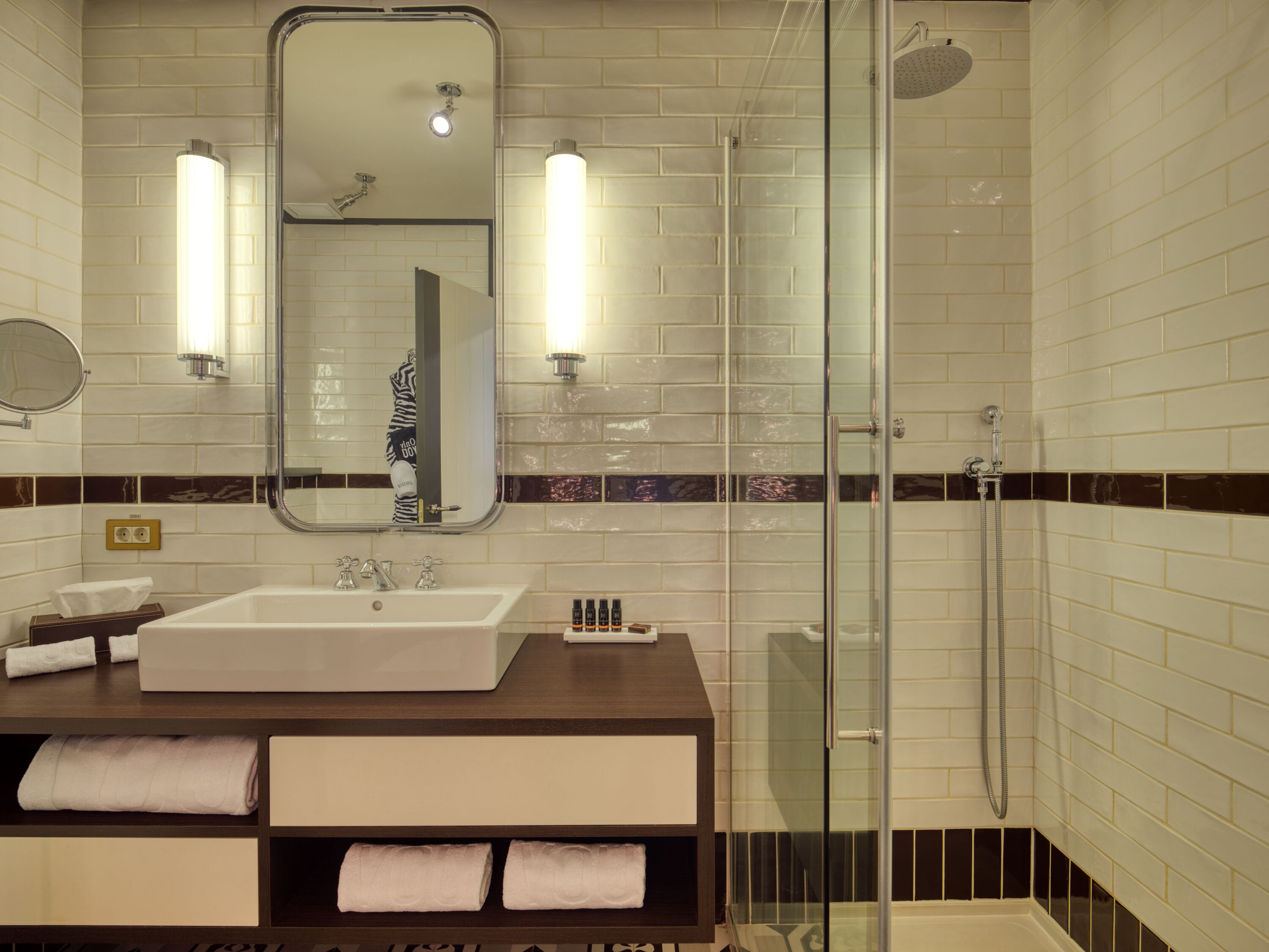 Baño con un espejo grande, un lavabo y cabina de ducha.