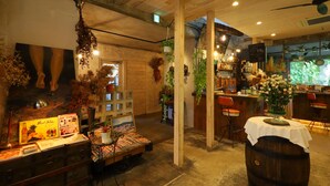 Un interior rústico con vigas de madera, una zona de bar y diversas plantas.