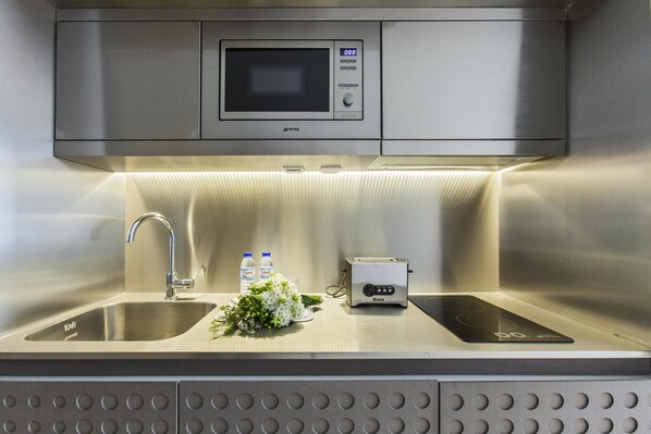 A modern kitchen with a built-in microwave, a toaster, and a sink.