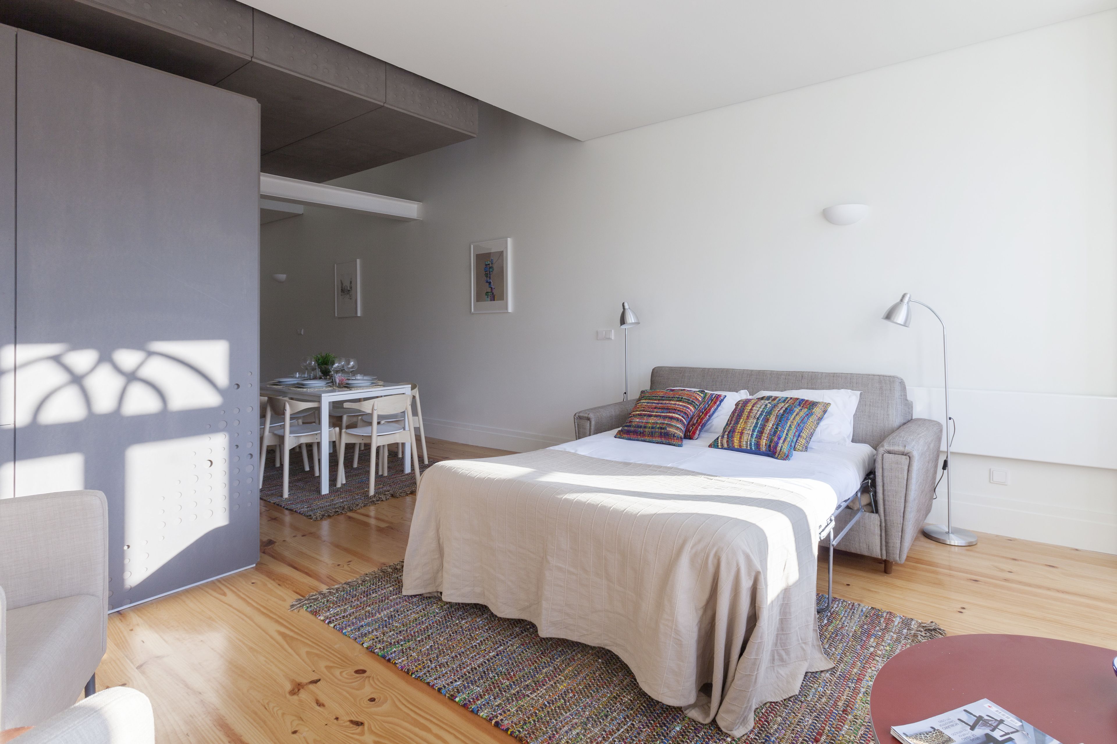 Ein modernes Schlafzimmer mit einem Bett, einem Nachttisch und einem Schreibtisch mit Stuhl.
