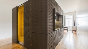 Een modern interieur met een geperforeerde wand, een schuifdeur en een inbouwkeuken.