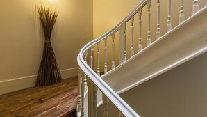 Een houten bank, een bezem en een witte trap met balustrades.