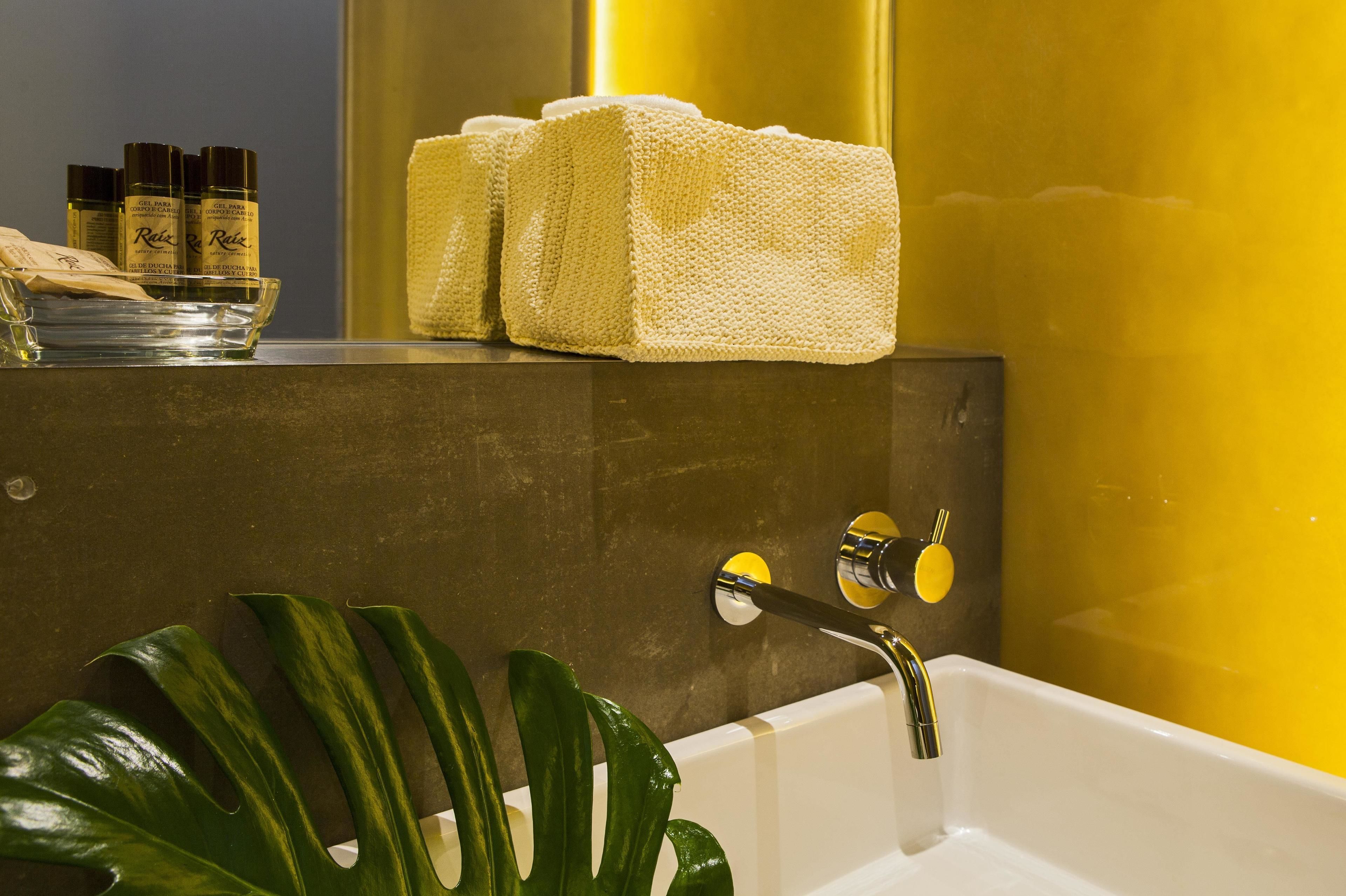 A bathroom with a bathtub, a towel rack with towels, and toiletries on a shelf.