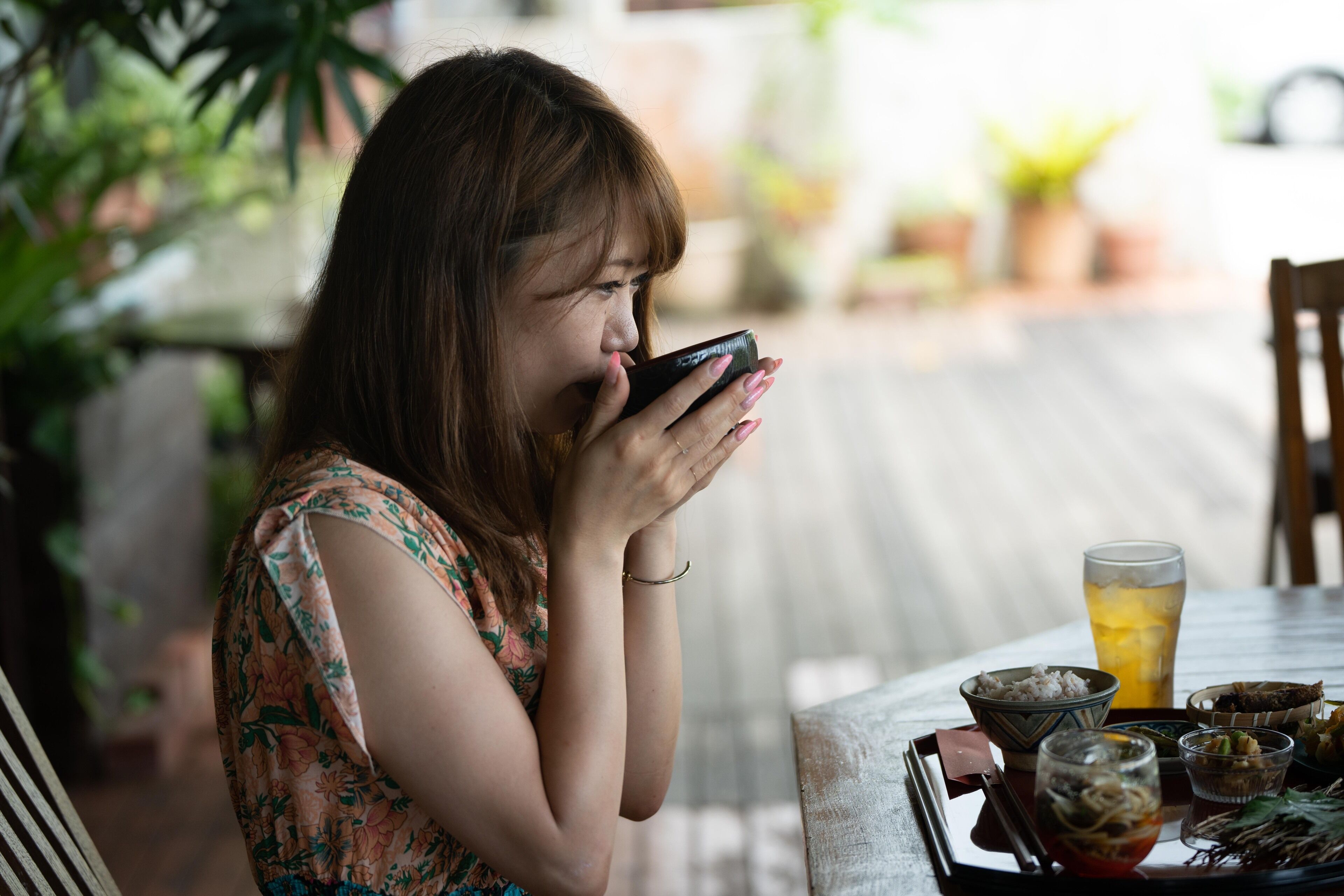 A person sitting at a table with various dishes and a drink.