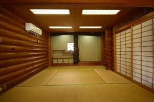 Una habitación japonesa tradicional con suelo de tatami, puertas correderas e interior de madera.