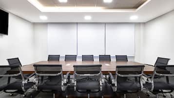 Un salón de conferencias con una larga mesa y ocho sillas.