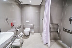 Ein modernes Badezimmer mit Toilette, Waschbecken und Duschbereich.