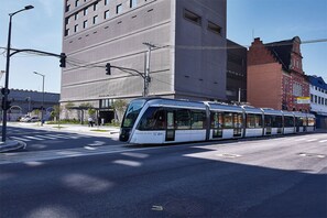Eine moderne Straßenbahnhaltestelle mit einer eleganten, weißen Straßenbahn.